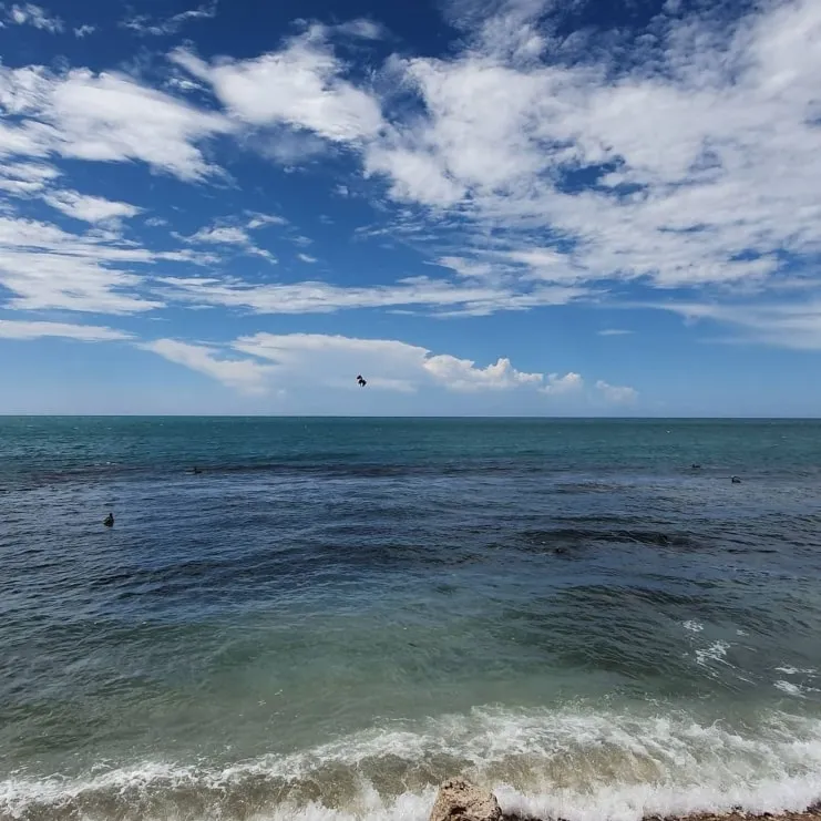 Waves rolling onto the shore at El Tuque in Ponce under a cloudy sky