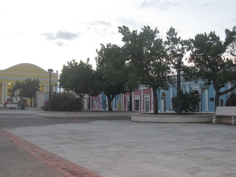 Town plaza in Vega Baja, Puerto Rico, with colorful buildings and trees
