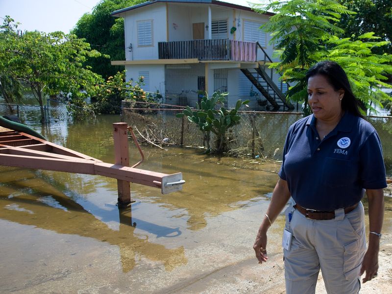 FEMA Community Relations representative Linda Colon surveys damage in a flooded neighborhood in Cabo Rojo, Puerto Rico