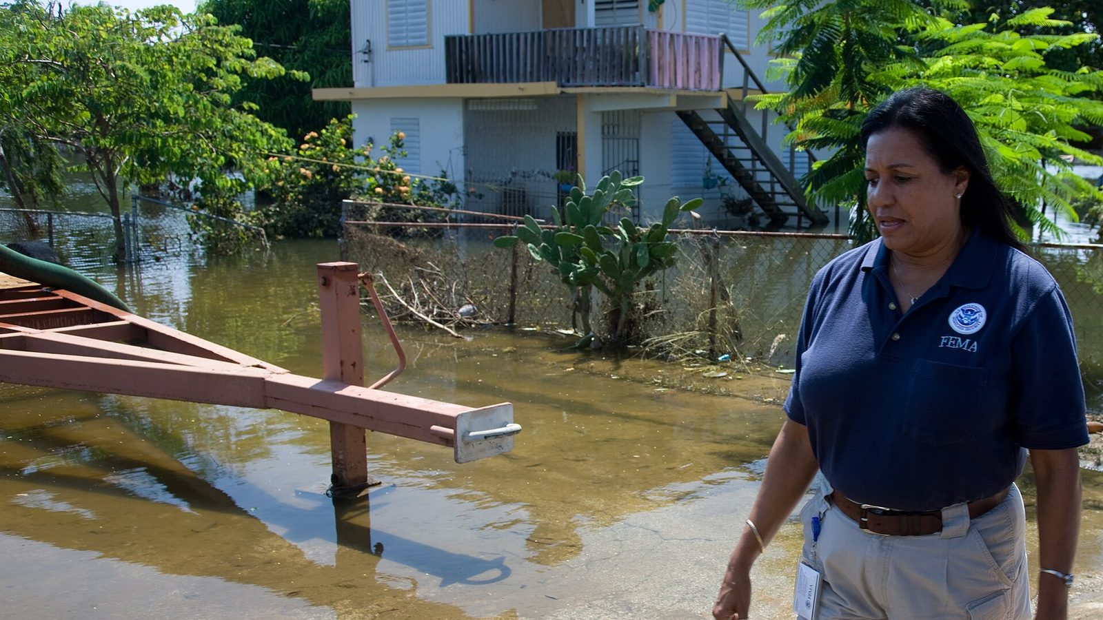 FEMA Community Relations representative Linda Colon surveys damage in a flooded neighborhood in Cabo Rojo, Puerto Rico