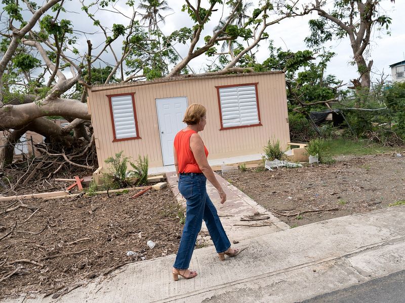 Julia Nazario Fuentes, Mayor of Loiza, walking past a damaged house in Loíza, Puerto Rico