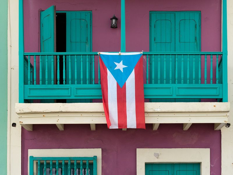 A Puerto Rican flag hanging from a balcony in Old San Juan