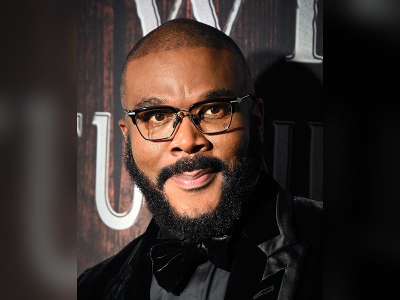 Tyler Perry, smiling, in glasses and a black velvet tuxedo with a bow tie, at a Broadway opening night in April 2026.