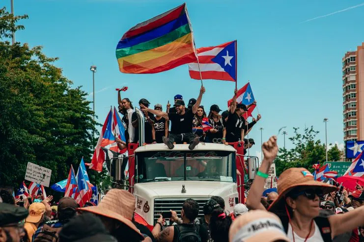 Bandera del orgullo y banderas de Puerto Rico en una manifestación en la calle