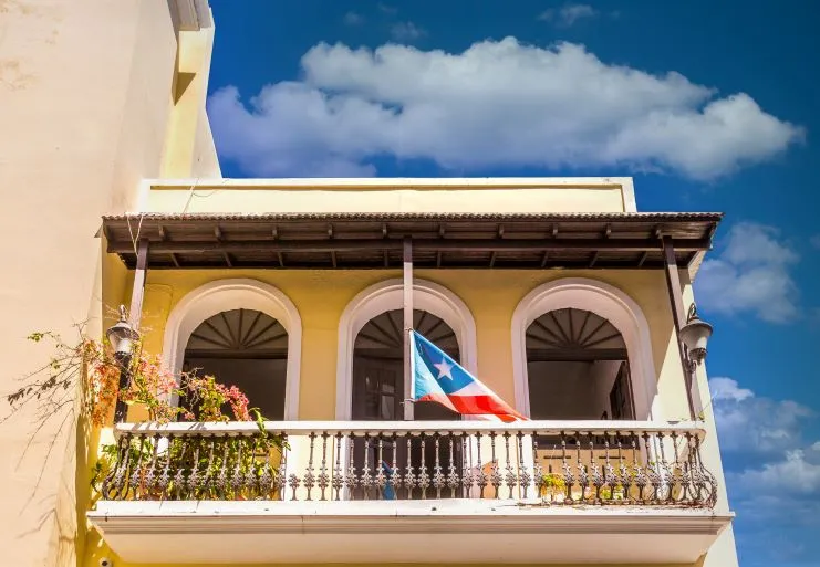 Balcón con una bandera de Puerto Rico en un edificio de colores de San Juan