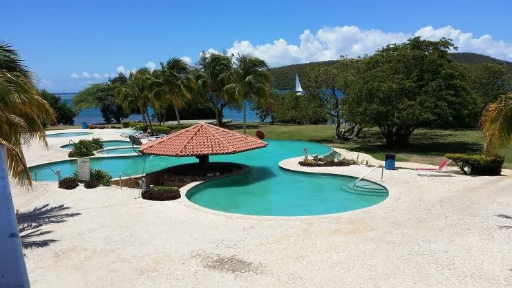 Área de piscina con sillas y sombrillas en una villa de Costa Bonita, Culebra