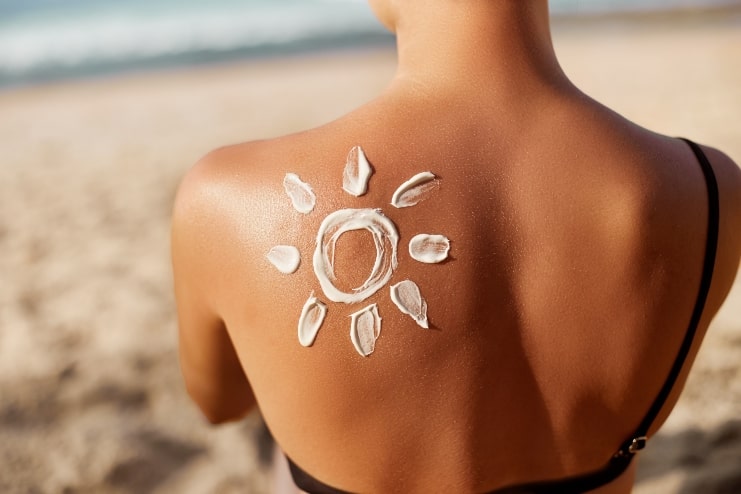 image of a lady with sun cream on her back