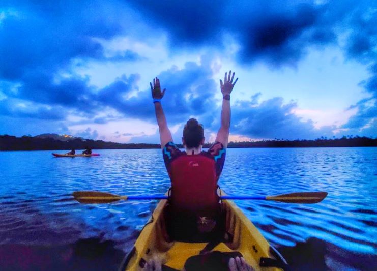 image of a girl kayaking in bioluminescent