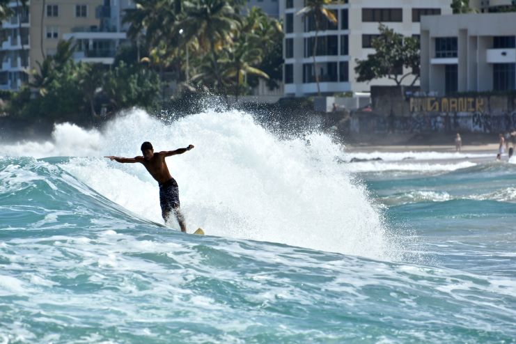 image of a guy surfing in Condado