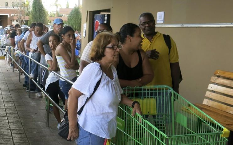 image of people waiting in line to buy food before a hurricane hits the Island