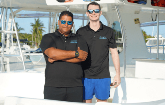 two men standing next to each other on a boat